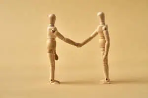 wooden figurines shaking hands, trust