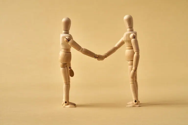 wooden figurines shaking hands, trust