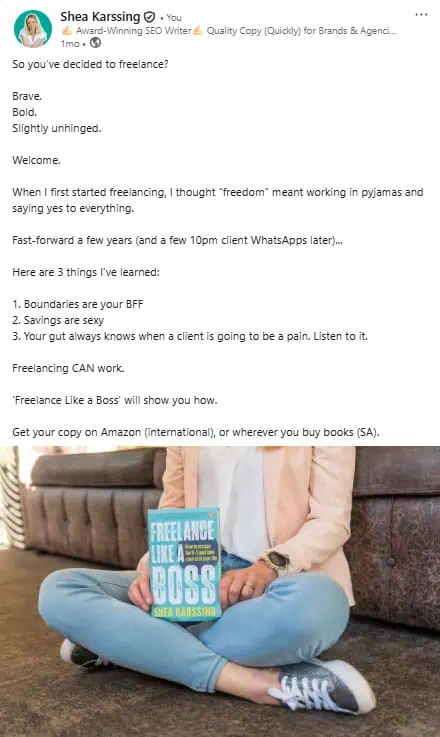 Freelancer sitting on the floor holding a book titled "Freelance Like a Boss" by Shea Karssing, promoting freelance success and independence.